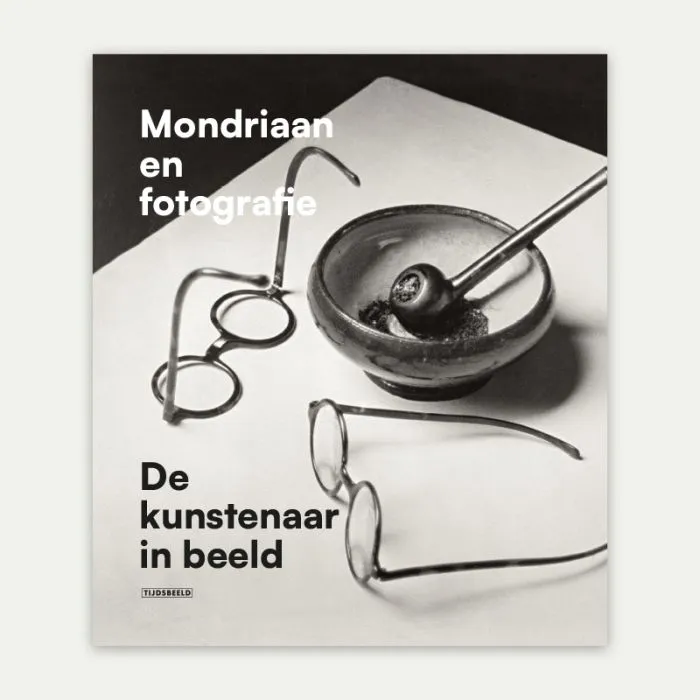Boekcover met de titel Mondriaan en fotografie, met een kunstzinnige foto van twee brillen en een asbak met een pijp, verwijzend naar Mondriaans persoonlijke objecten