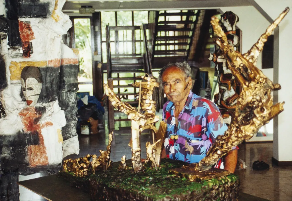Erwin de Vries zit bij een model van het slavernijmonument.